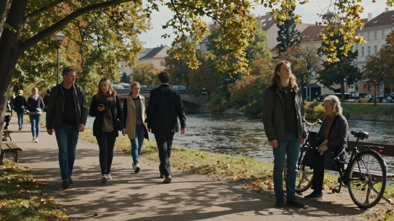 Lidé procházejí parkem u řeky Svitavy v českém městě.